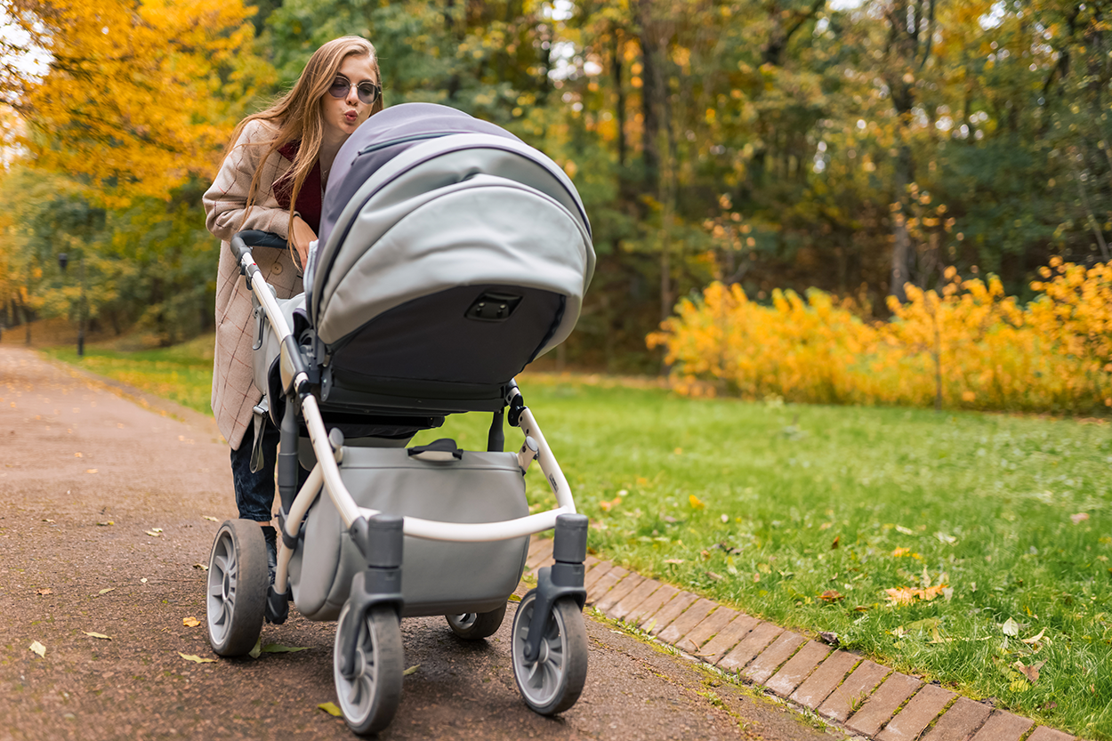 cheerful-mother-with-stroller-walks-in-autumn-par-2024-10-18-08-19-52-utc